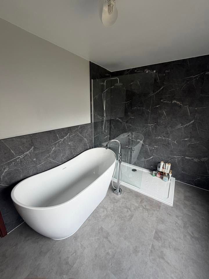 Bath and shower with grey wall tiles