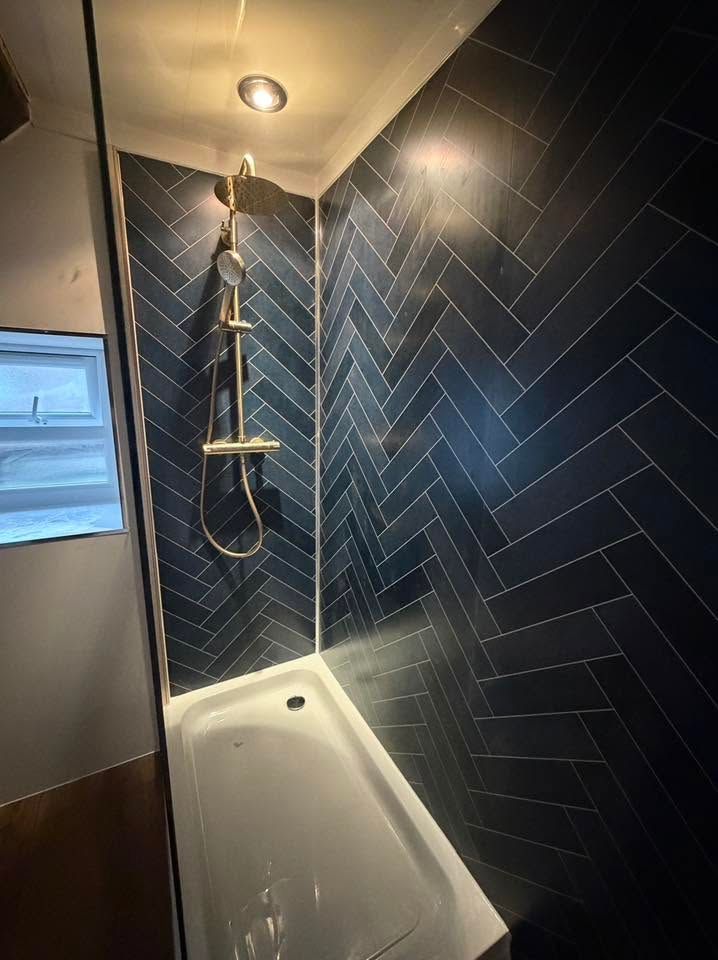 Shower with dark herringbone tiles